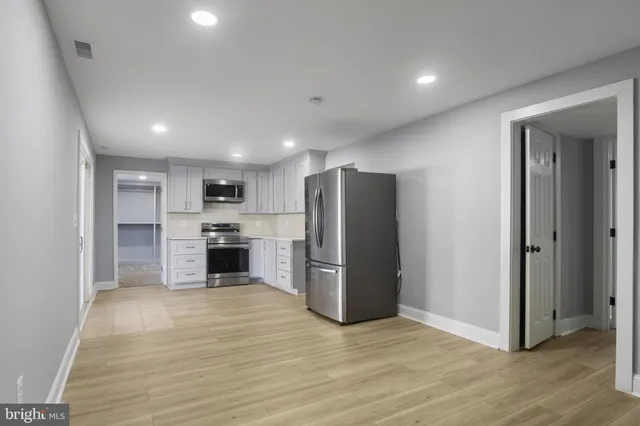 a view of kitchen view wooden cabinets and stainless steel appliances