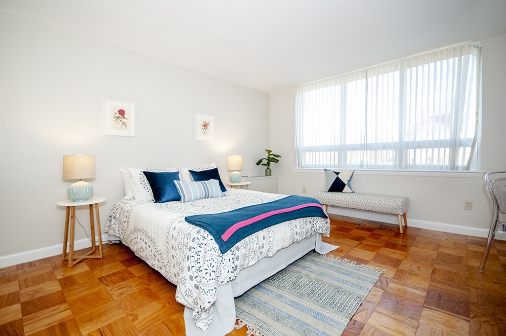 41 Park Street, Unit 207 Brookline, MA 02446 - Photo 12 of 25 a spacious bedroom with a bed and a lamp
