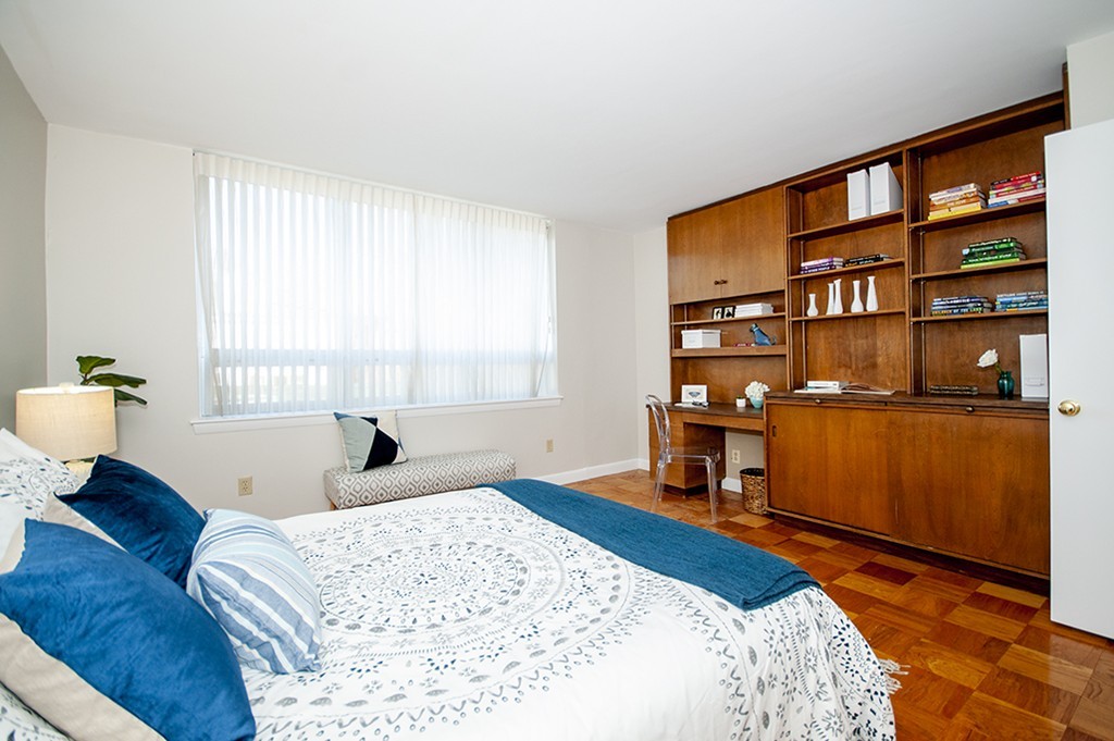 41 Park Street, Unit 207 Brookline, MA 02446 - Photo 13 of 25 a bedroom with a bed and a bookshelf