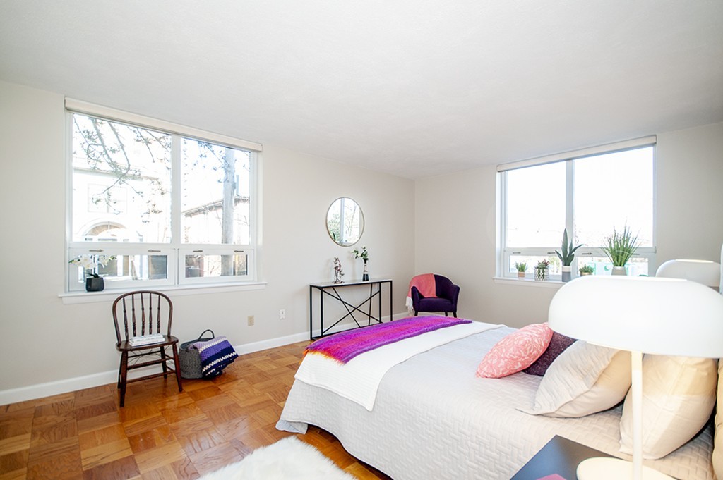 41 Park Street, Unit 207 Brookline, MA 02446 - Photo 17 of 25 a bedroom with a bed a large window and a table