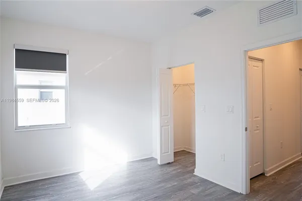 an empty room with wooden floor and a window