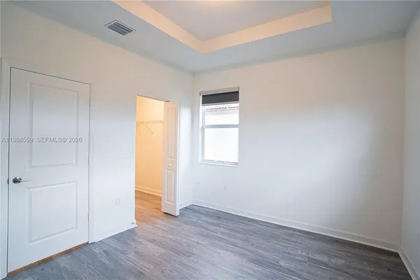 an empty room with wooden floor and window