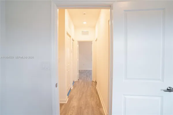 a view of a hallway with wooden floor