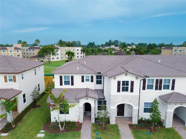a aerial view of a house with a yard and balcony