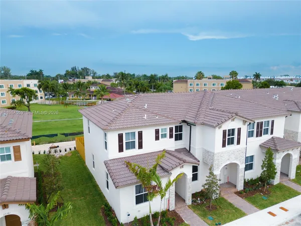 a aerial view of a house with a yard and potted plants