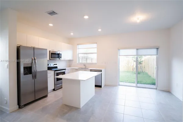 a kitchen with a sink a counter top space and stainless steel appliances