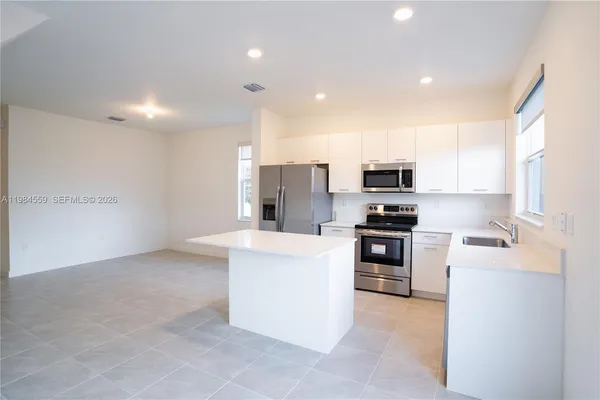 a kitchen with stainless steel appliances granite countertop a refrigerator oven a stove top oven a sink and dishwasher