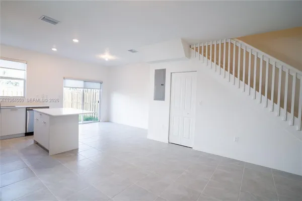 a view of a kitchen with wooden floor and a sink