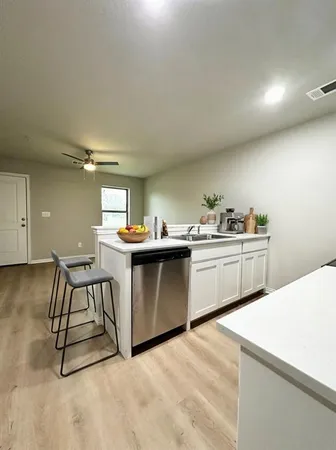 a kitchen with a sink a stove cabinets and counter space