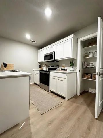 a kitchen with a sink a stove and cabinets