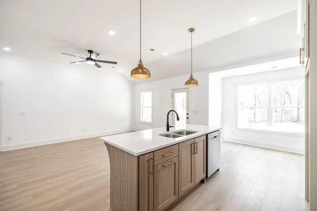 a kitchen with a sink cabinets and wooden floor