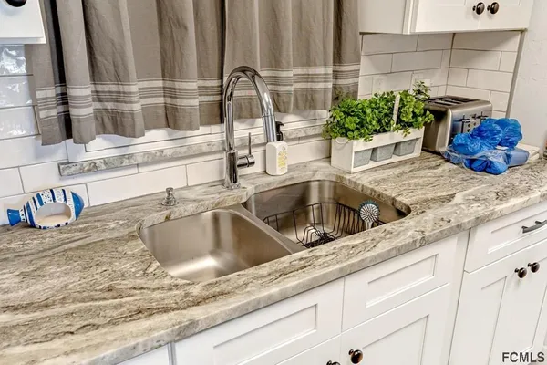a kitchen sink with granite countertop a sink and a wooden floor