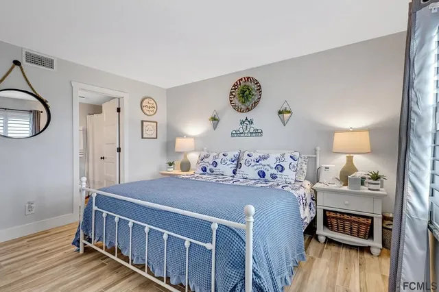 a bedroom with a bed and wooden floor