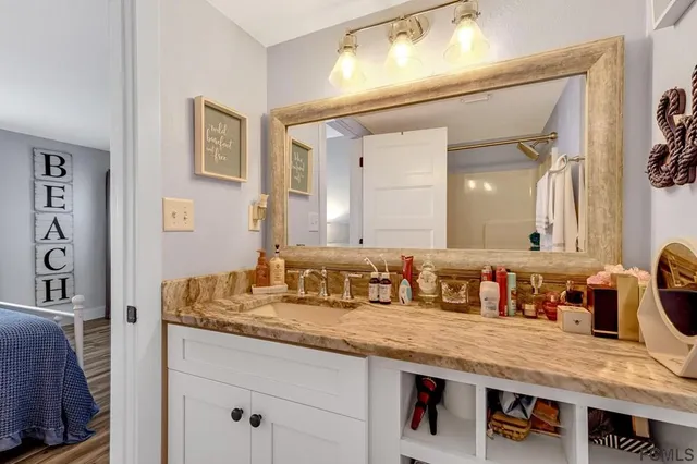 a bathroom with a granite countertop sink a large mirror and vanity