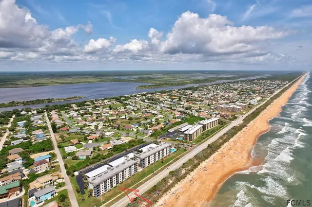 a living room with furniture a bookshelf and a window