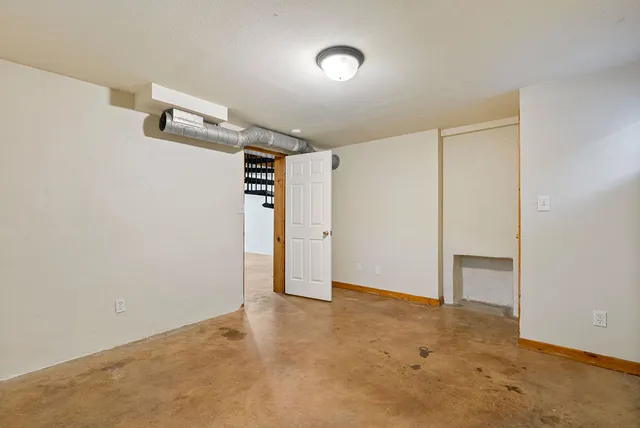 an empty room with closet and windows