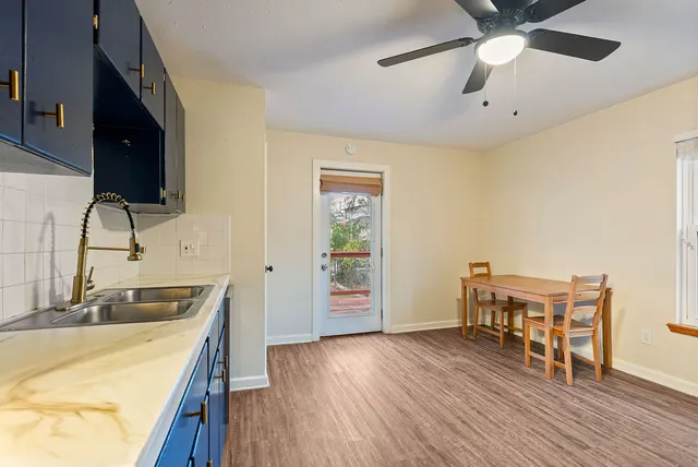 a kitchen with stainless steel appliances granite countertop a sink dishwasher and a stove with wooden floor