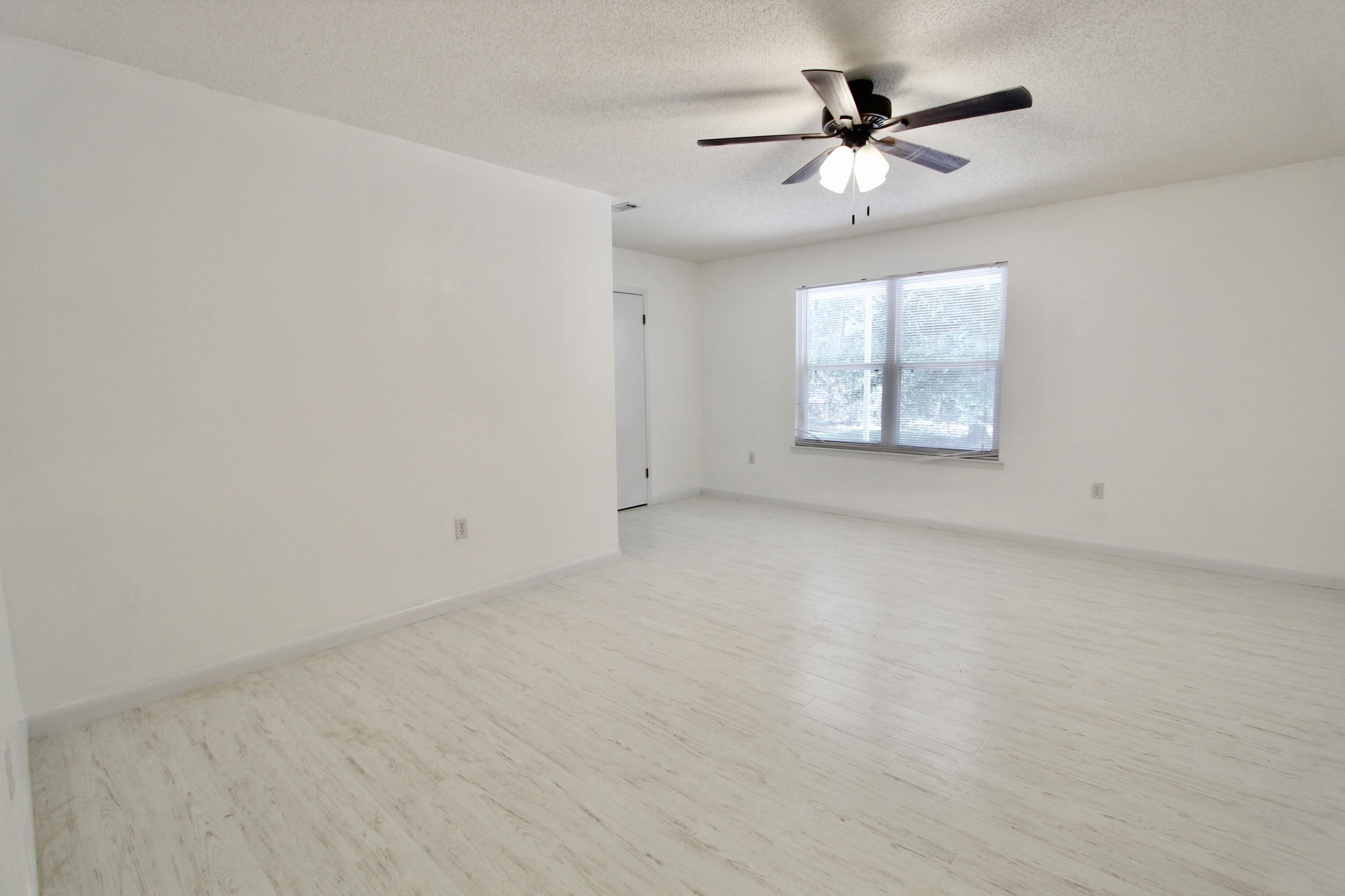 1088 Tallokas Road Crestview, FL 32536 - Photo 6 of 16 an empty room with windows and chandelier fan