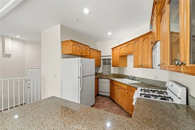 a kitchen with stainless steel appliances granite countertop a refrigerator and a stove