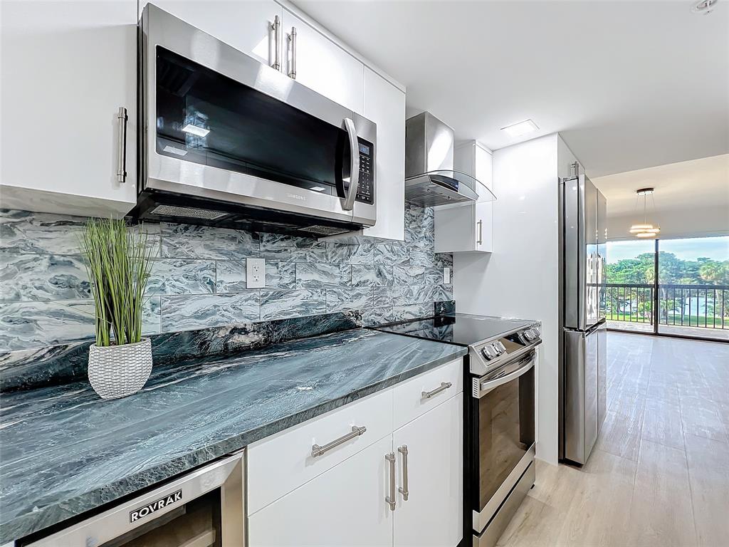 364 Golfview Road, Unit 507 North Palm Beach, FL 33408 - Photo 12 of 25 a kitchen with stainless steel appliances granite countertop a sink a stove and microwave