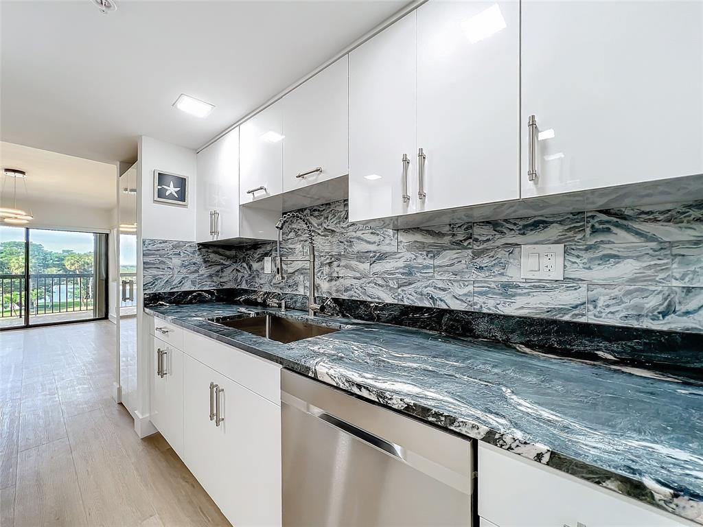 364 Golfview Road, Unit 507 North Palm Beach, FL 33408 - Photo 13 of 25 a kitchen with stainless steel appliances granite countertop a sink stove and cabinets