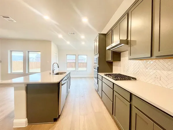 a kitchen with granite countertop a sink and a stove top oven