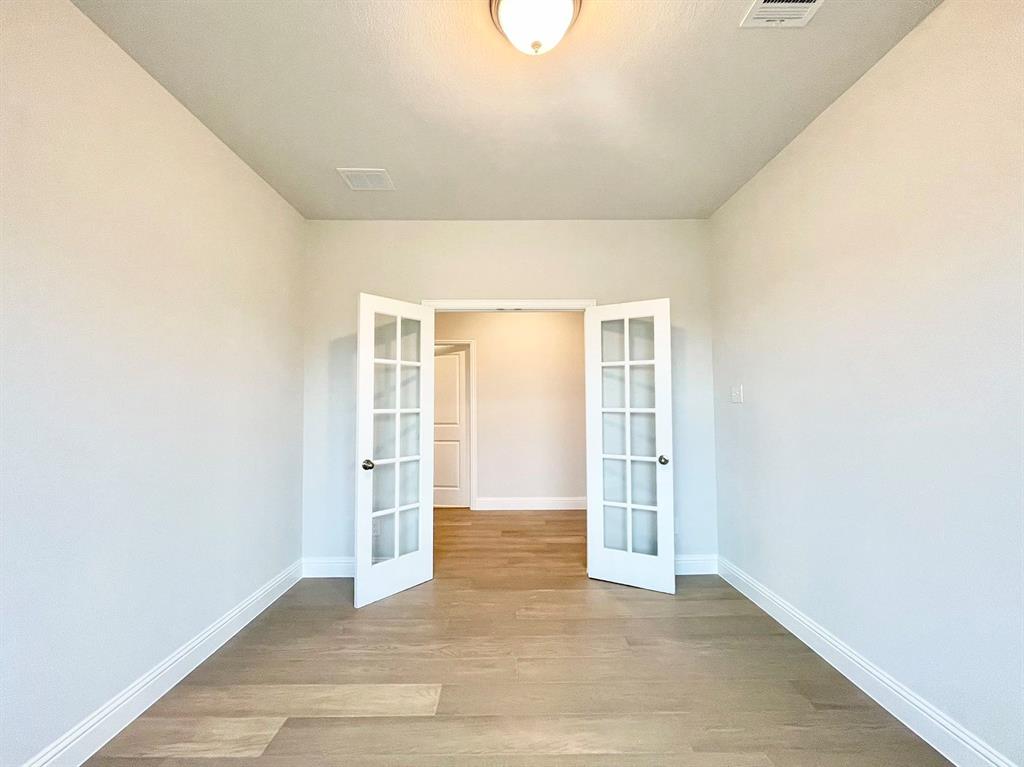 13705 Riola Drive Little Elm, TX 75068 - Photo 14 of 40 an empty room with wooden floor and windows