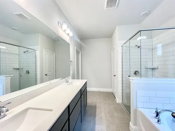 a spacious bathroom with a bathtub shower sink and mirror