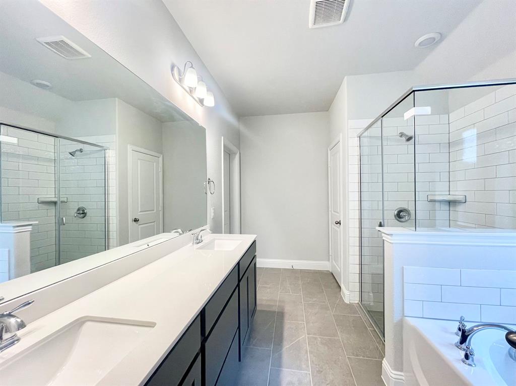 13705 Riola Drive Little Elm, TX 75068 - Photo 17 of 40 a spacious bathroom with a bathtub shower sink and mirror