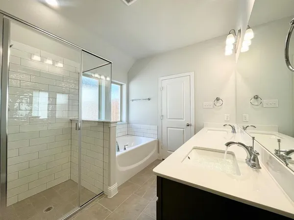 a bathroom with a tub sink shower and two mirror