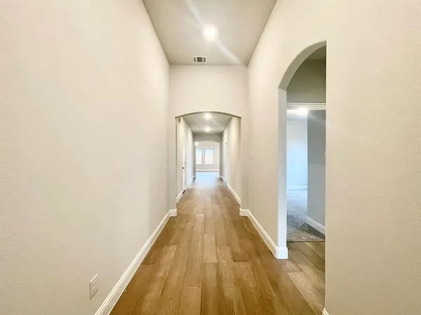 a view of a hallway with wooden floor