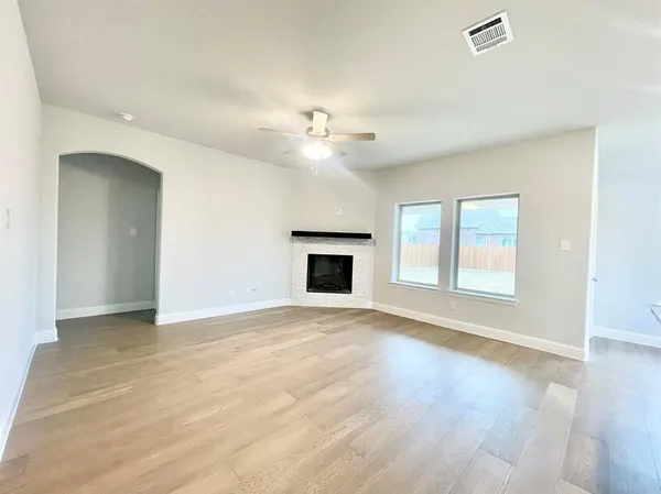 a view of an empty room with a fireplace and a window