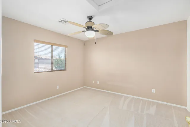 an empty room with a window and a fan