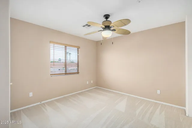 an empty room with a window and a fan