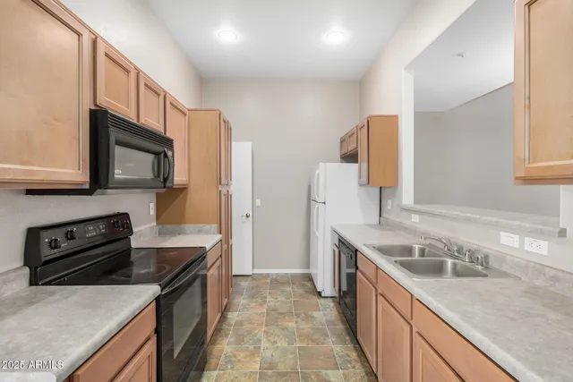 a kitchen with stainless steel appliances granite countertop a sink stove microwave and refrigerator