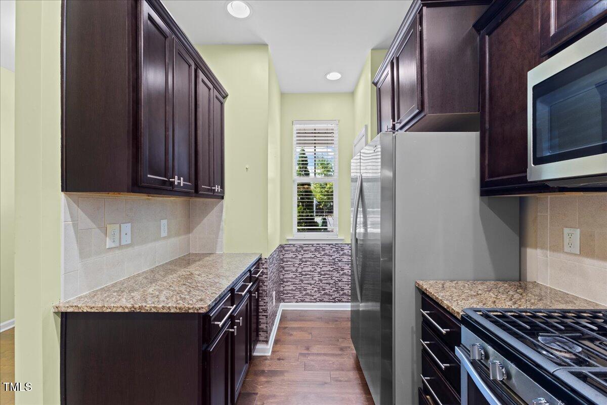 106 Churment Court Durham, NC 27703 - Photo 10 of 50 a kitchen with stainless steel appliances granite countertop wooden cabinets and a stove top oven