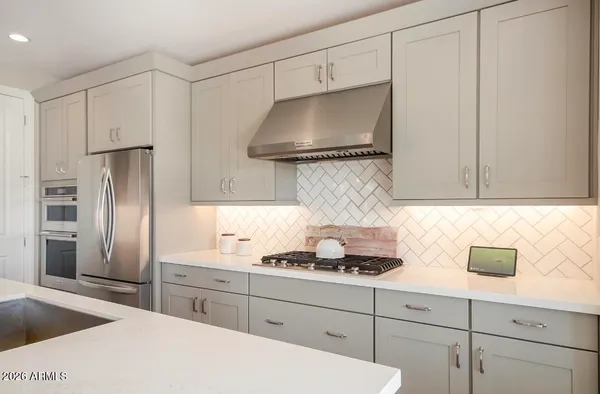 a kitchen with stainless steel appliances white cabinets and a sink