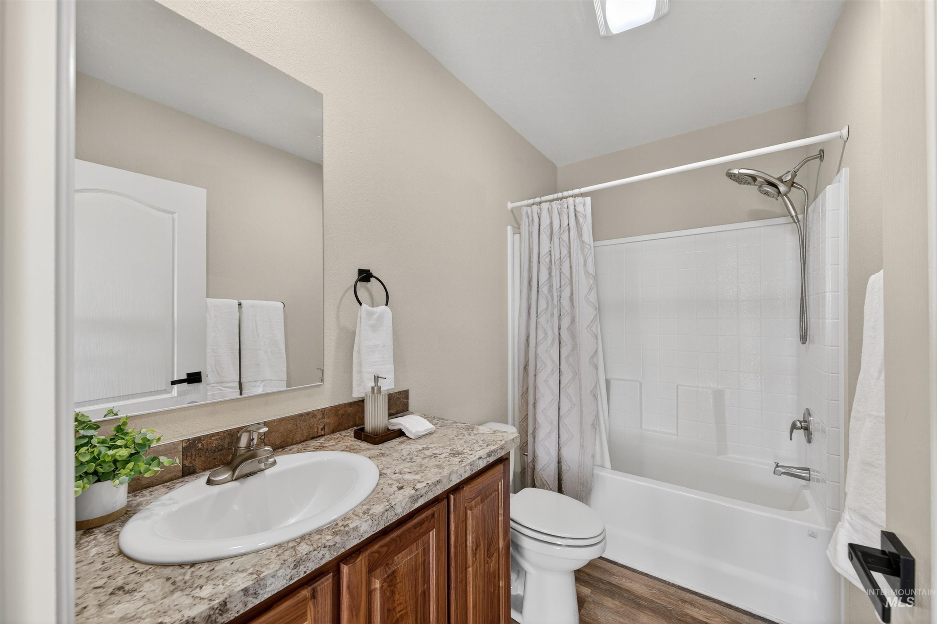 1203 Locker Avenue Parma, ID 83660 - Photo 29 of 49 Full bathroom with shower / bath combo with shower curtain, vanity, and dark wood-style floors