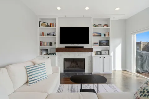 a living room with furniture a flat screen tv and a fireplace
