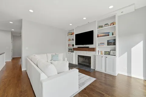 a living room with furniture a flat screen tv and a fireplace