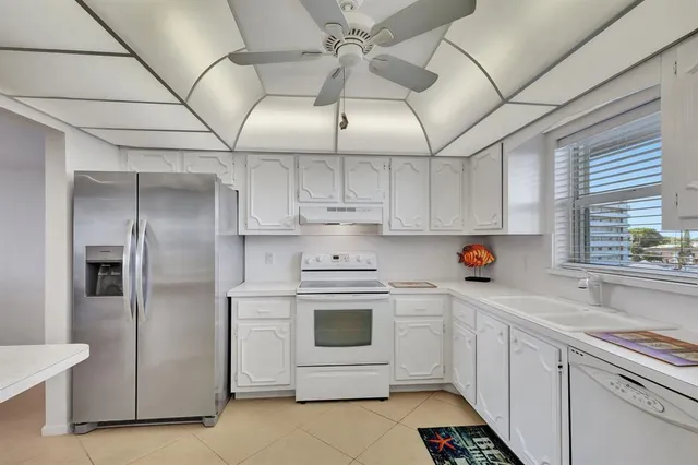 a kitchen with stainless steel appliances white cabinets and white appliances