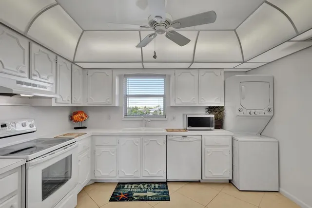 a kitchen with white cabinets and white appliances