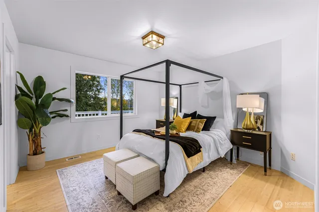 a bedroom with a bed a dresser and a potted plant