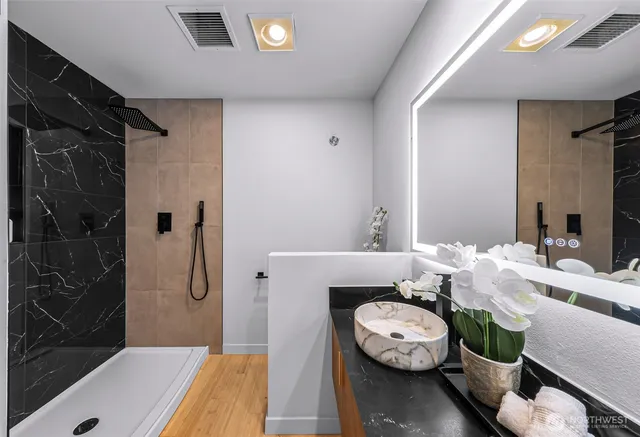 a bathroom with a granite countertop sink a toilet and shower