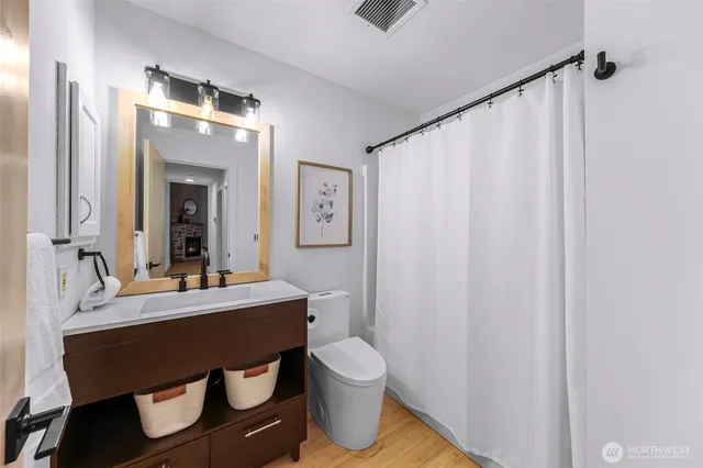 a bathroom with a sink vanity mirror and toilet