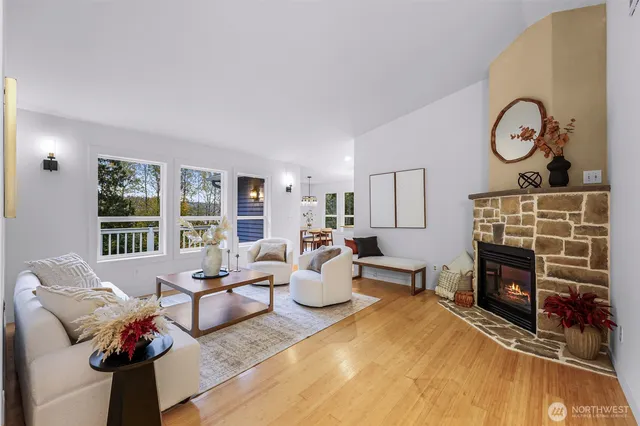 a living room with furniture a fireplace and a large window
