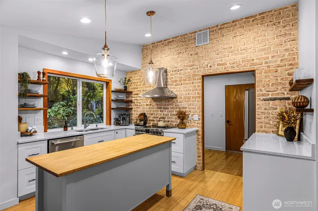 a view of a kitchen with a sink and large window