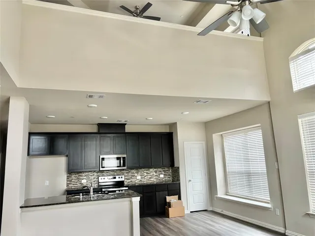 a kitchen with stainless steel appliances granite countertop a stove a sink and a refrigerator