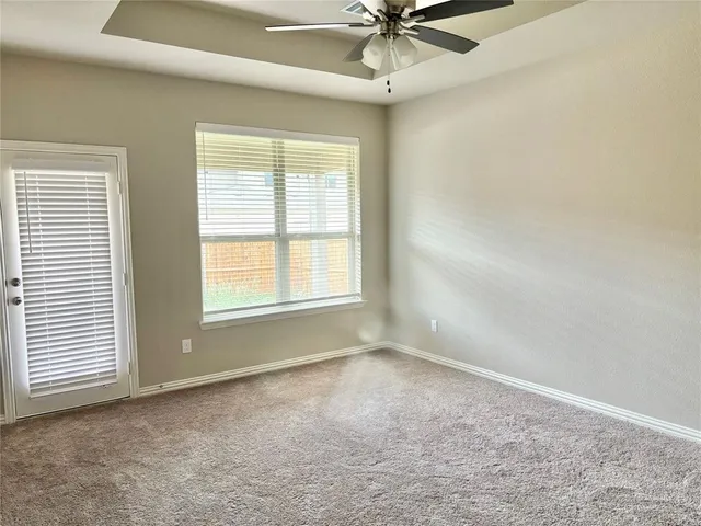 an empty room with a window and a fan