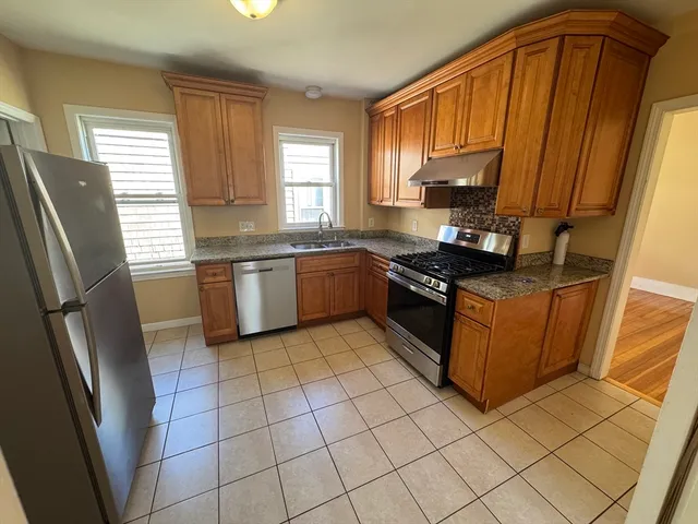 a kitchen with stainless steel appliances granite countertop a stove a sink and a refrigerator